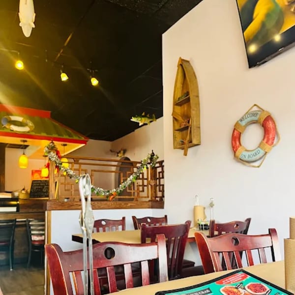 Interior of Cajun Crab restaurant with nautical decor, wooden chairs, and tables set for dining.