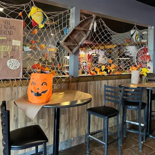 Cajun Crab restaurant interior with Halloween decor, fishing nets, and wooden boat accents.